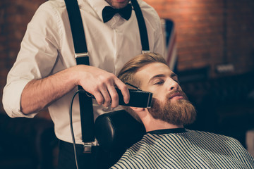 Close up cropped photo of a hairdresser`s work for a handsome young guy at the barber shop. He is...