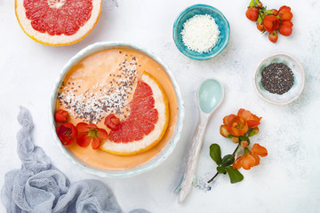 Healthy breakfast set. Superfoods smoothie bowl with chia seeds, coconut, grapefruit and quince flowers. Overhead, top view, flat lay.