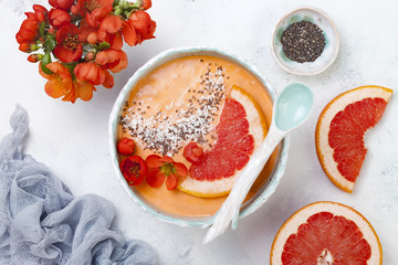 Healthy breakfast set. Superfoods smoothie bowl with chia seeds, coconut, grapefruit and quince flowers. Overhead, top view, flat lay.