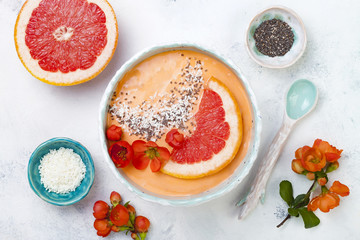 Healthy breakfast set. Superfoods smoothie bowl with chia seeds, coconut, grapefruit and quince flowers. Overhead, top view, flat lay.