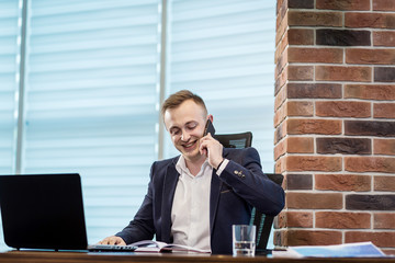 A businessman talking on a mobile phone,Businessman talking on the phone in office,Senior businessman,Portrait of businessman talking on mobile phone,business concept