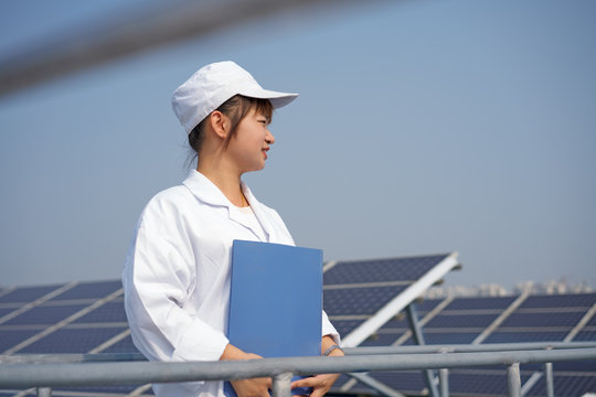 Female worker on roof of solar panel assembly factory, Solar Valley, Dezhou, China