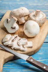 Sliced raw mushrooms on a chopping board.