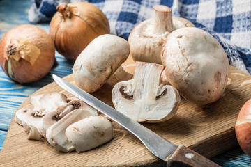 Sliced raw mushrooms on a chopping board.