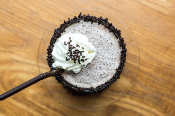 Top view of chocolate frappe with whipped cream on wooden table background