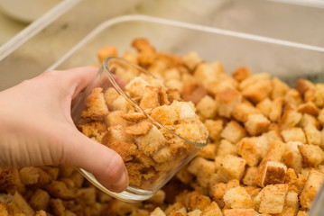 Scooping home made croutons in glass