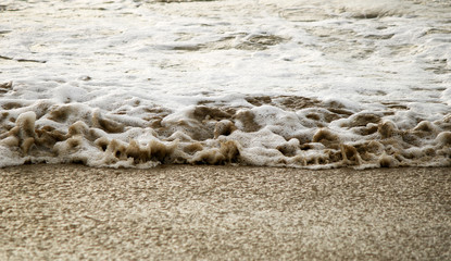 Close view of a dirty foamy ocean wave coming