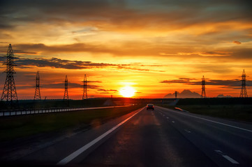 Fototapeta na wymiar Highway with cars traveling on the sunset .