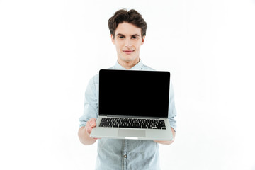Portrait of a smiling man showing blank screen laptop computer