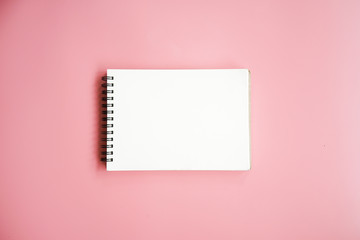 Blank notebook on pink background.