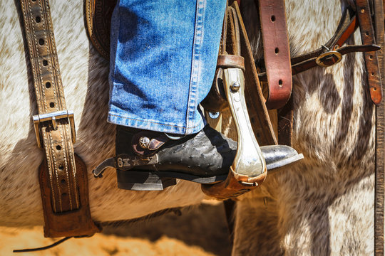 Close up of a cowboy boot in the stirup of a horse at a rodeo