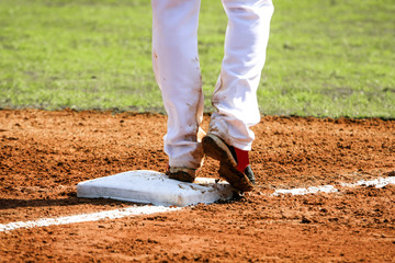 Fototapeta na wymiar Baseball player with his foot on a base plate