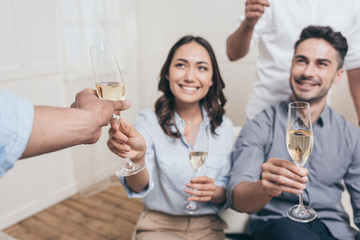 young smiling friends drinking champagne at home party