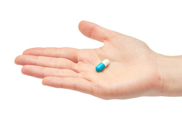 Beautiful female hand holds pill gesture. Isolated on white background