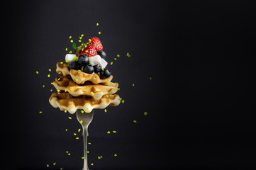 A stack of Belgian waffles with berries.(Strawberry, blueberry), marshmelow, and chocolate sauce on a fork, with levitation - 159611299