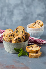 Italian cantuccini in a ceramic bowl on a table, with a red checkered napkin - 159611462