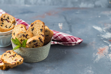 Italian cantuccini in a ceramic bowl on a table, with a red checkered napkin - 159611487