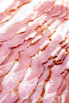 Close-up, background of raw bacon, a popular meat product, ingredient of many dishes.