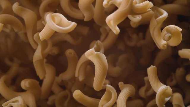 Raw cellentani pasta flies after being exploded. Shot with high speed camera, phantom flex 4K. Slow Motion.