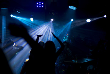 Fototapeta na wymiar Dancing People Silhouette Under Blue Lights in A Club