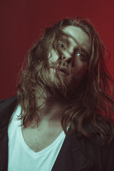 Portrait of young bearded man with long hair looking away