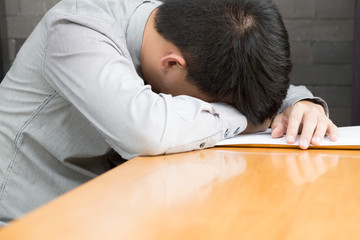 Tired businessman sleeping on wood table at office