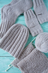 knitted clothes on turquoise wooden background