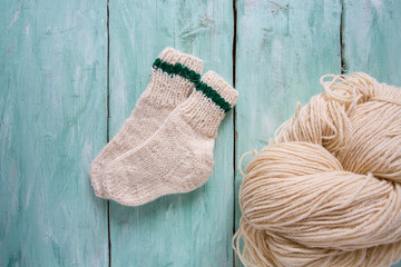 knitted socks and yarn on wooden surface