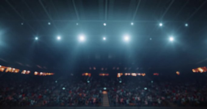 4k video footage of an indoor floodlit basketball arena full of spectators.
