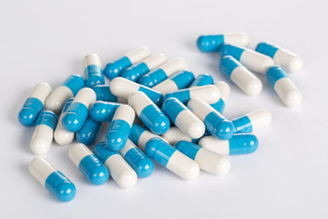 Closeup of medical blue pills on the white background.