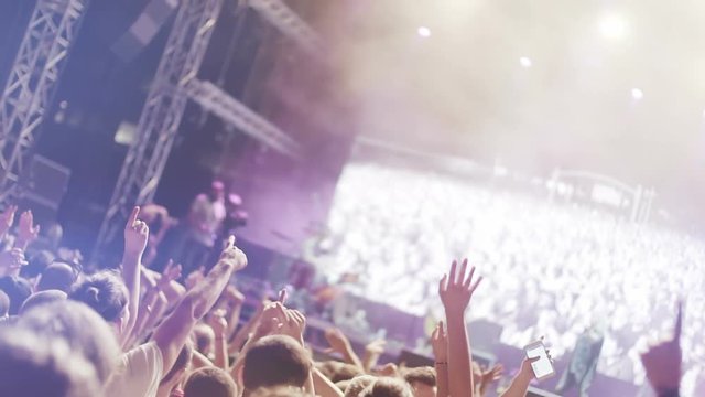 Iconic rock concert front row crowd cheering hands in air slomo crane pan 100p