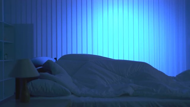The man and woman have a sex under duvet on the bed. night time
