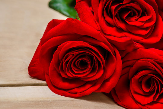 Red roses lying on a wooden table