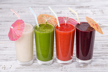 Fresh avocado, strawberry, blueberry and banana drinks on wooden table, assorted protein cocktails with fresh fruits.