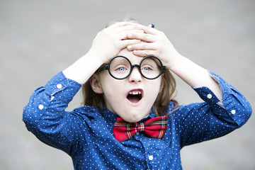 boy with bow tie and big glasses looking upset
