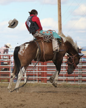 Cowboy riding a saddle bronc at a rodeo