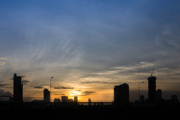 The silhouette of Bangkok city and construction building in evening sky in summer