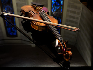 Violin on the grand piano in a concert hall