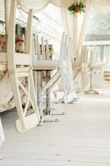 White chairs on tables upside down on street cafe summer terrace.