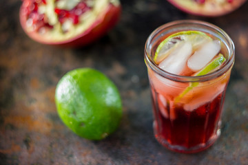 Fresh pomegranate drink - lemonade or cocktail with lime and ice