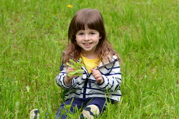 Little girl's portrait on a green grass