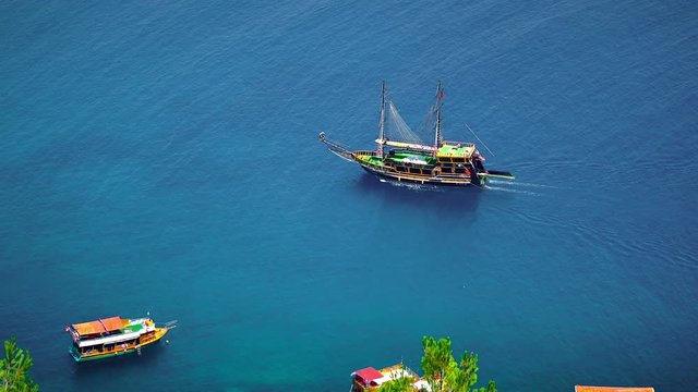 Gulet yacht cruising on the calm waters of Alanya Harbor. Gulet is a traditional design of a two-masted wooden sailing vessel from southwestern coast of Turkey, built in the coastal towns of Bodrum an
