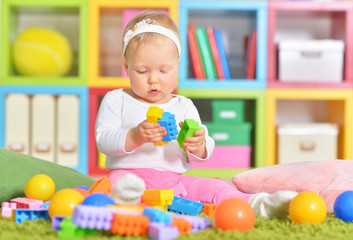 Fototapeta na wymiar Adorable little child playing with colorful toys 