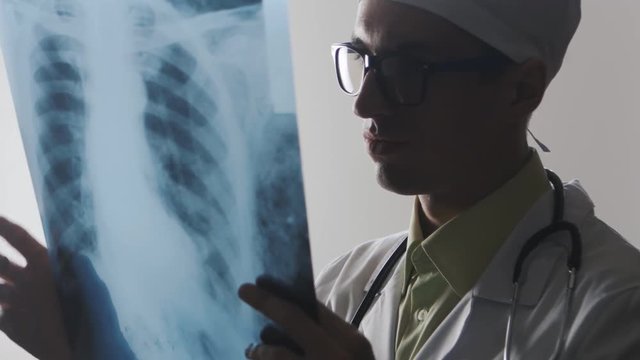 The doctor is studying an X-ray. The medical worker makes a good diagnosis
