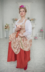 Beautiful woman in medieval dress holding pink rose