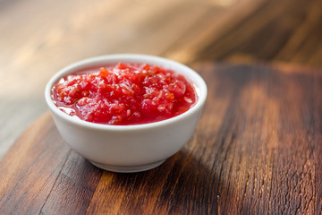 Indian chutney or mexican salsa in white ceramic bowl.