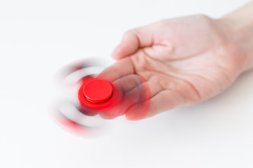 close up of fidget spinner rotating on female hand over white