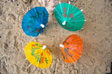 Umbrella for cocktails on a sandy summer background.