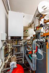 Household boiler room with gas boiler, barrel; Valves; Sensors and a lot of pipes in a small room