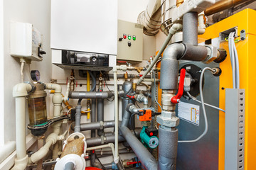 Household boiler room with gas boiler, barrel; Valves; Sensors and a lot of pipes in a small room